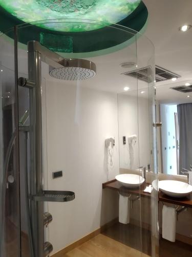 a bathroom with two sinks and a mirror at Hotel Campoamor in Oviedo
