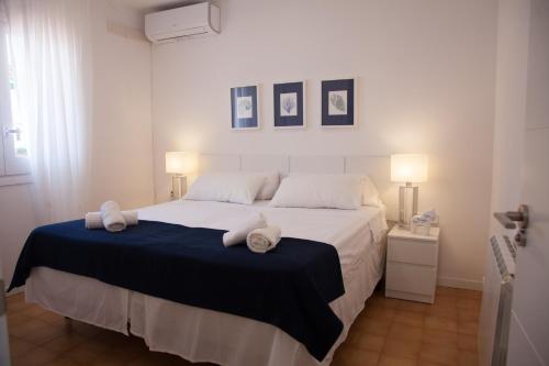 una camera da letto con un grande letto bianco con asciugamani sopra di New Opening Villa Oasis Terramar a Sitges