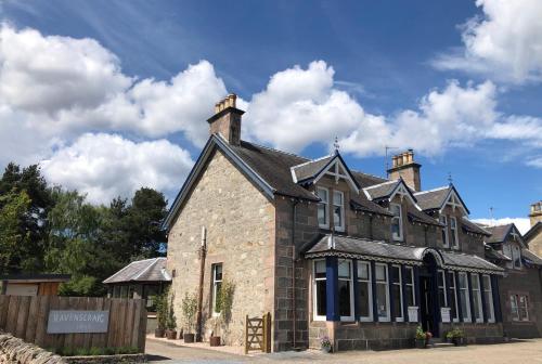 a large brick building with two chimneys at Ravenscraig Guest House in Aviemore