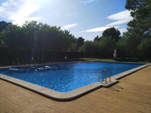 a swimming pool with blue water in a park at Casas Rurales el Cerrete de Haro in Fuentelespino de Haro