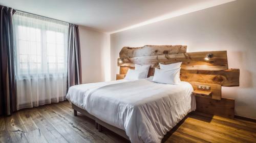 a bedroom with a large bed with a wooden headboard at Hotel Keimberg in Cleebourg