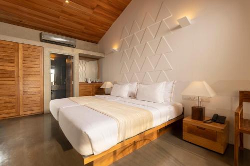 a bedroom with a large bed with white sheets at Giritale Hotel in Polonnaruwa