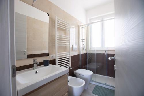 bagno con lavandino bianco e servizi igienici di Villa Zaffiro a Siracusa