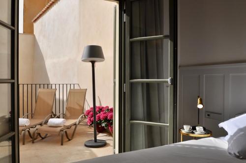 a bedroom with a bed and chairs and a table at Hotel Basilica in Palma de Mallorca
