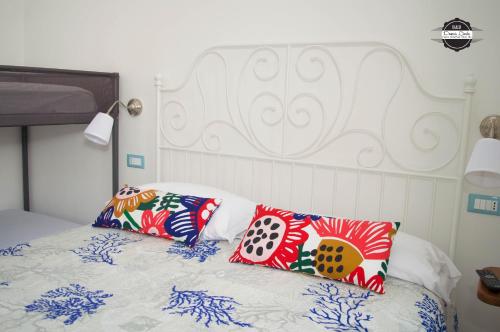 una cama con almohadas coloridas encima en Domus Linda B&B, en Isquia