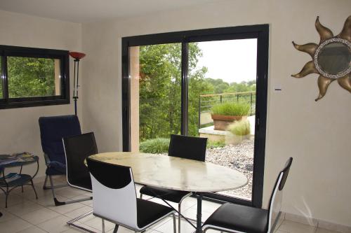 une salle à manger avec une table et des chaises et une fenêtre dans l'établissement Chambre d'hôtes La Dentalie, à Rouffignac-Saint-Cernin-de-Reilhac