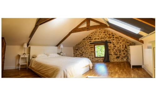 1 dormitorio con 1 cama blanca en un edificio de piedra en The Cider House: charming 2 bedroom cottage en Mellac