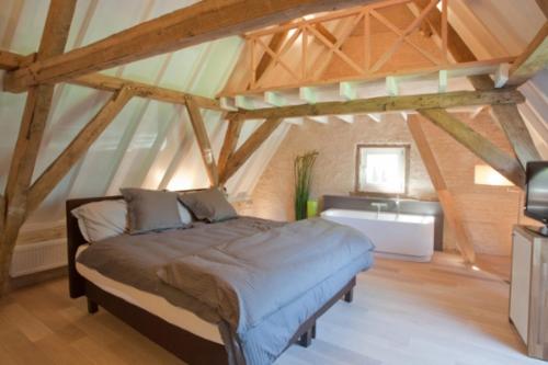 a bedroom with a bed in a attic at Hostellerie Hof Ter Doest in Lissewege