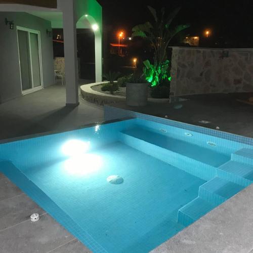 a swimming pool lit up at night at Kostas Studios in Faliraki