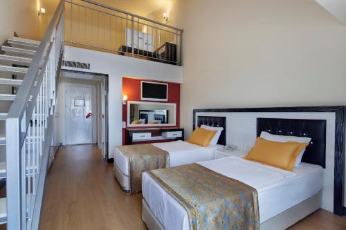 a hotel room with two beds and a staircase at Senza The Inn Resort & Spa - Ultra All Inclusive in Avsallar