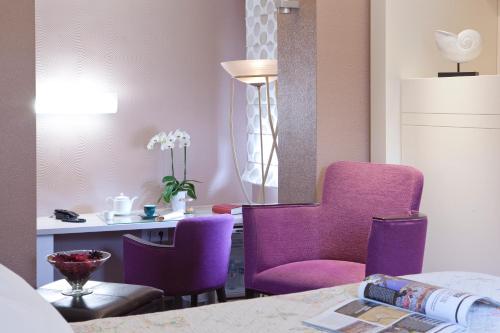 a living room with purple chairs and a table at Le Rhien Hôtel-Restaurant in Ronchamp