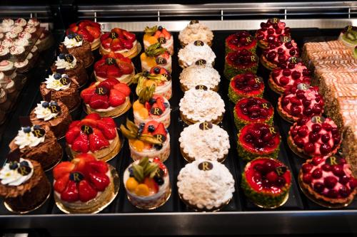 a display case with many different types of cakes at Gästehaus Rössler in Brannenburg