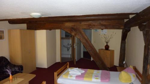 a bedroom with a bed with wooden beams at Altstadt Pension Hafenblick in Stralsund