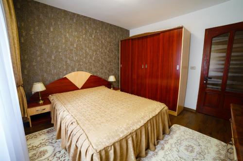 a bedroom with a bed and a red cabinet at ROMANTIK APARTMENTS in Câmpulung Moldovenesc