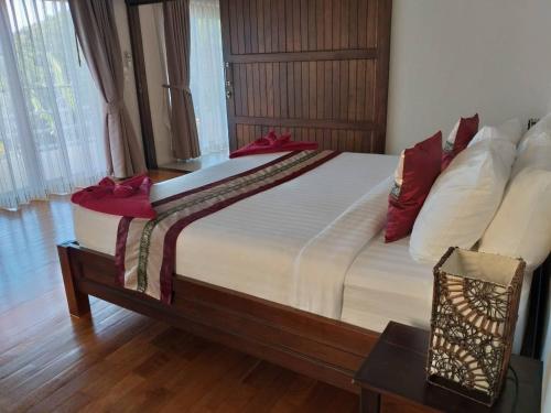 una camera da letto con un grande letto con cuscini rossi di Koh Phangan Pavilions Serviced Apartments a Thong Nai Pan Noi