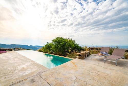 a swimming pool with two chairs on a patio at Agrikea in Korissia
