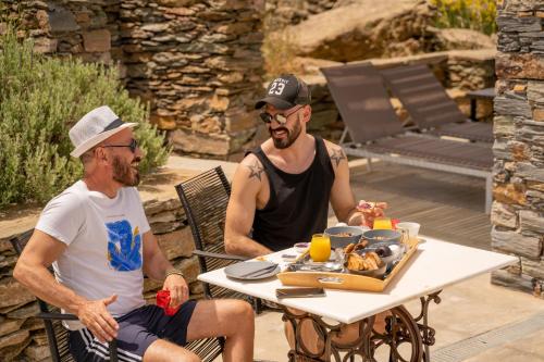 two men sitting at a table with a tray of food at Agrikea in Korissia