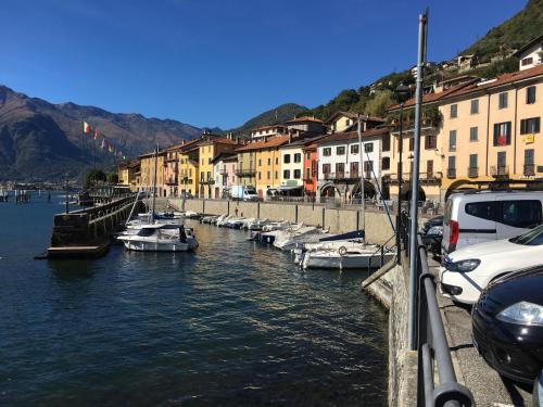 a group of boats docked in a river with buildings at Residence Domaso - Esperienza in Centro Storico "Casa del Dottore" in Domaso
