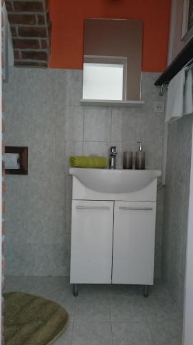 a bathroom with a white sink and a mirror at Apartments Mare in Hvar