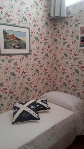 a bedroom with a bed with flowers on the wall at Elegant and Sea View Excelsior Apartment in Levanto