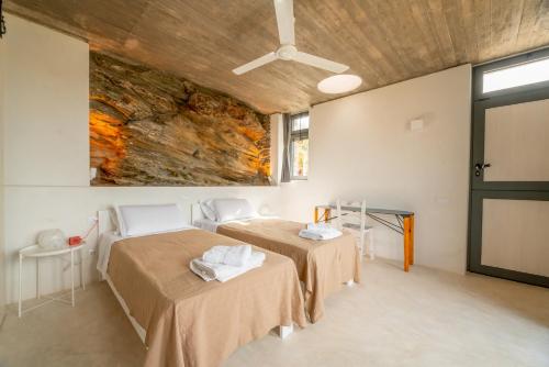 two beds in a room with a stone wall at Agrikea in Korissia