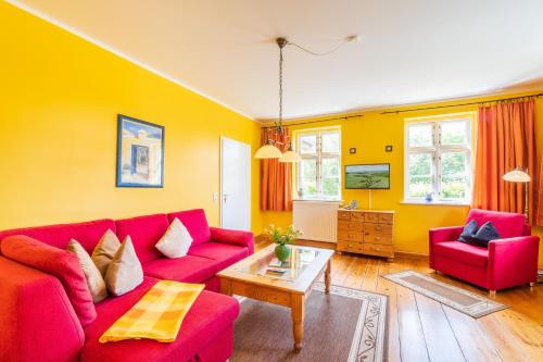 a living room with a red couch and a table at Vogelhaus Gobbin in Lancken-Granitz