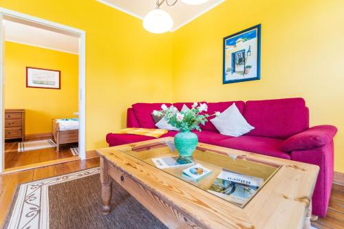a living room with a red couch and a table at Vogelhaus Gobbin in Lancken-Granitz