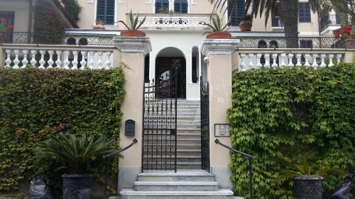 a white house with stairs leading to the front door at Elegant and Sea View Excelsior Apartment in Levanto