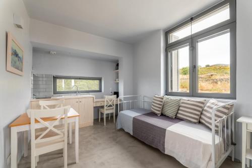 a bedroom with a bed and a desk and a kitchen at Agrikea in Korissia
