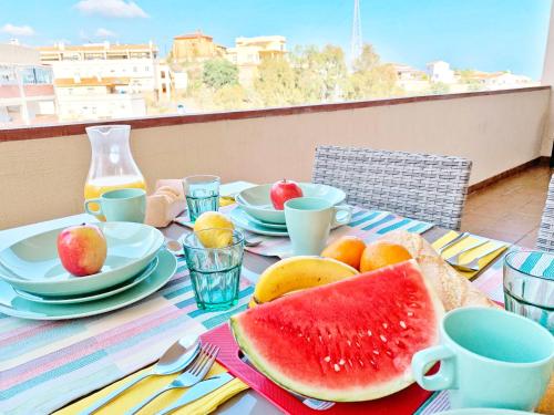 a table with a plate of watermelon and fruit on it at Apartamento Rincón, Ideal para familias in Cala del Moral