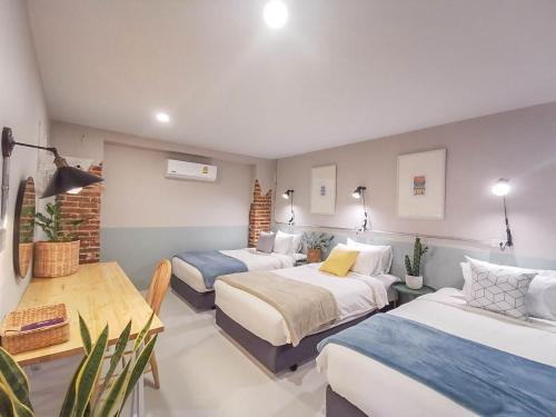 Snoozy Guesthouse في فوكيت تاون: غرفة فندقية بسريرين وطاولة