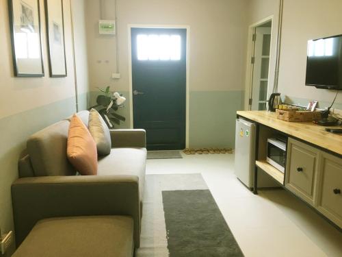 a living room with a couch and a black door at Snoozy Guesthouse in Phuket Town