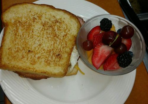 um prato branco com uma sanduíche e uma taça de fruta em Inap.Inap Karimunjawa em Karimunjawa