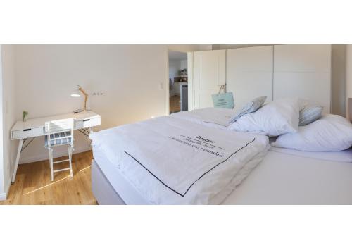 two beds in a room with a desk and a bed sidx sidx sidx at Gästehaus hygge in Nübbel