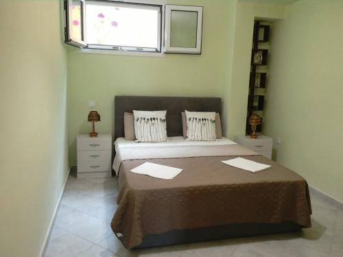 a bedroom with a large bed with a window at Trizinia View Garden in Galatas