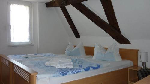 a bed with blue and white pillows on it at Altstadt Pension Hafenblick in Stralsund