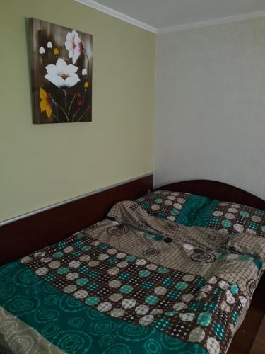 a bed with a quilt on it in a bedroom at Pensiunea Red Rock in Piatra Neamţ