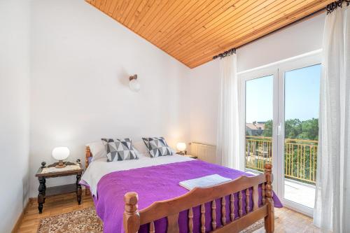 a bedroom with a large bed and a large window at Apartments Klavdija in Vodice