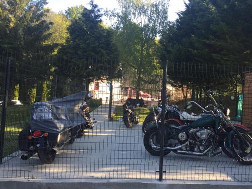 a couple of motorcycles parked next to a fence at La Table Des Bons Peres in Bislée