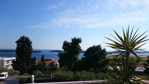 a view of the ocean from a street with trees at Apartments Mare in Hvar