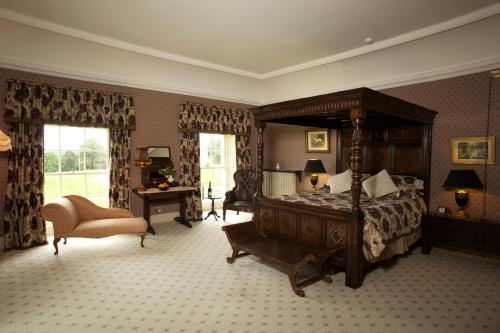 a bedroom with a canopy bed and a chair at Grange Manor in Ballyragget