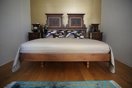 a bedroom with a large bed with a wooden headboard at Kolovrathome in Ljubljana