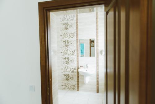 a bathroom with a sink and a toilet and a mirror at Hotel Korona in Kolybayevka