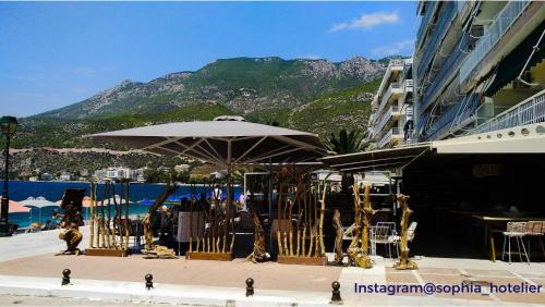 a table with an umbrella in front of a building at Loutraki Suites in Loutraki