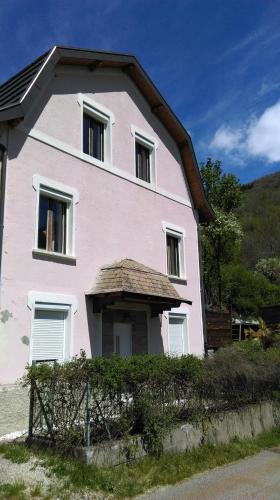 een roze huis met een hek ervoor bij maison rose in La Villette