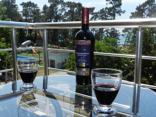 uma garrafa de vinho sentada numa mesa com um copo em Hotel BellMar em Kobuleti