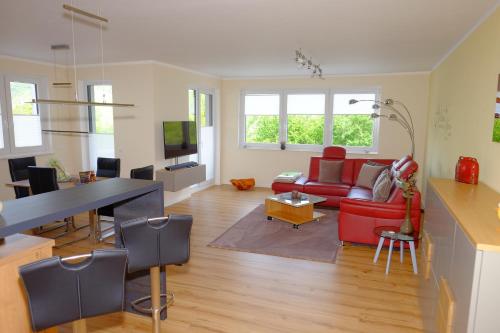 a living room with a red couch and a table at RheinWeinBoppard 2 - mit Rheinblick in Boppard