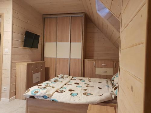 a bedroom with a bed and wooden walls at Willa Myśliwska dom 10-osobowy ZE STREFĄ BASENOWĄ w miejscowości Chocznia NIEDALEKO ZATORU I ENERGYLANDII in Chocznia