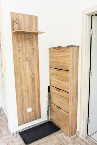 a closet with wooden drawers and a cabinet with a black rug at Apartment Sea&Sky in Tivat