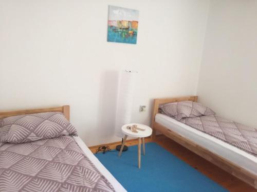 a bedroom with two beds and a small table at Holiday Home Iman in Sarajevo